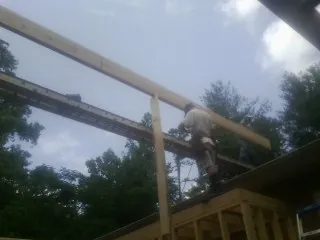 Carpenter setting a ridge beam over a new addition frame — Ice Dam Removal by Roofing Brothers in Grove