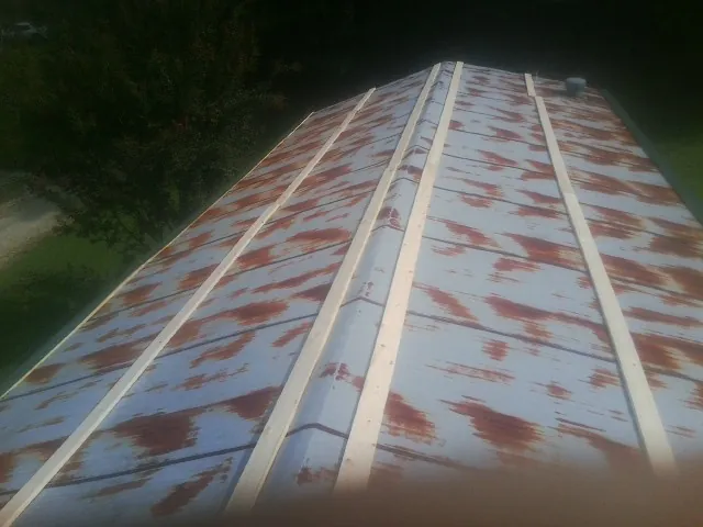 Rusted metal roof panels with new wood purlins before replacement — Storm Damage Roof Repair in Grove by Roofing Brothers