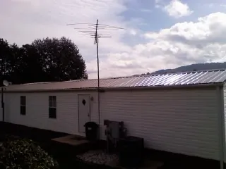 New metal roof on a single wide mobile home with a TV antenna in Grove
